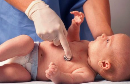 врач осматривает новорожденного